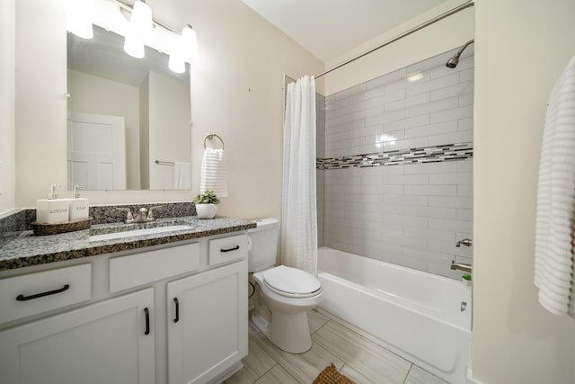 bathroom featuring toilet, shower / bath combo with shower curtain, and vanity