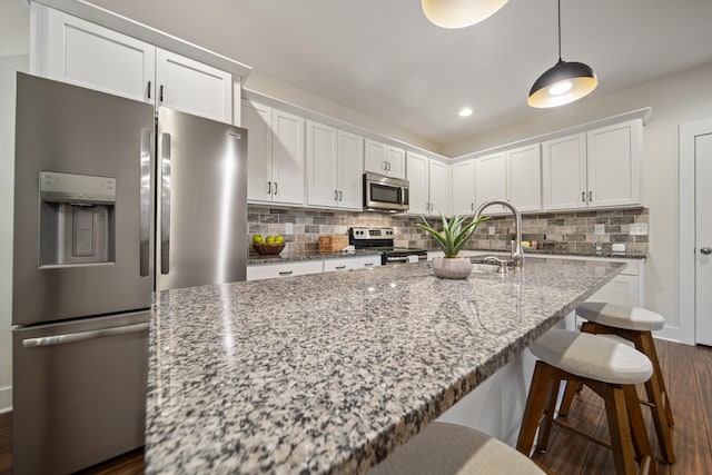 kitchen featuring stainless steel appliances, white cabinets, and decorative backsplash