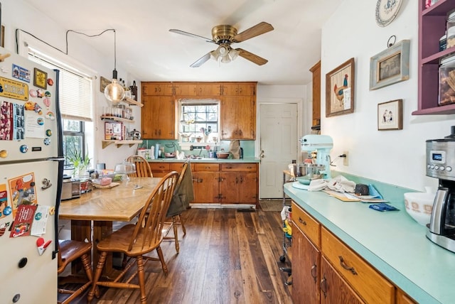 kitchen featuring brown cabinets, open shelves, freestanding refrigerator, ceiling fan, and dark wood-style flooring