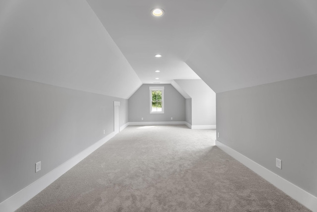 additional living space with carpet floors, recessed lighting, vaulted ceiling, and baseboards