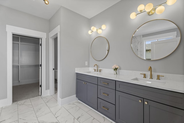 full bath featuring marble finish floor, a sink, baseboards, and double vanity