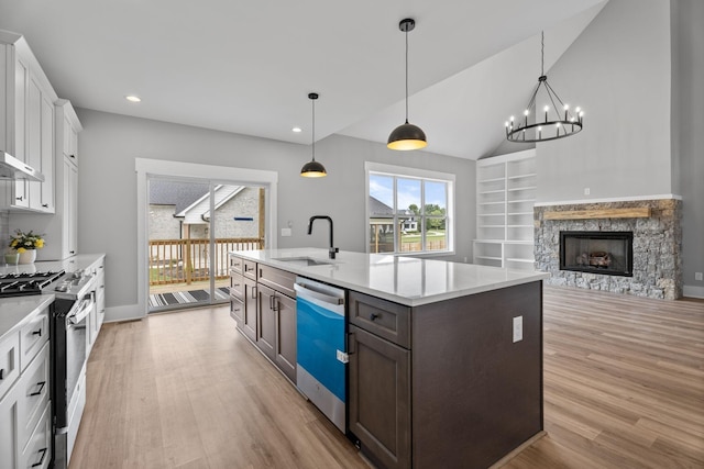 kitchen with light countertops, white cabinets, a sink, stainless steel gas range, and dishwasher