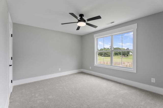 empty room with baseboards, carpet flooring, visible vents, and a ceiling fan