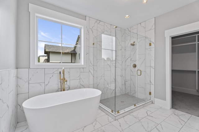 bathroom featuring a marble finish shower, a soaking tub, marble finish floor, a walk in closet, and recessed lighting