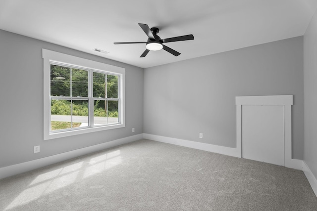 empty room featuring baseboards, carpet flooring, visible vents, and a ceiling fan