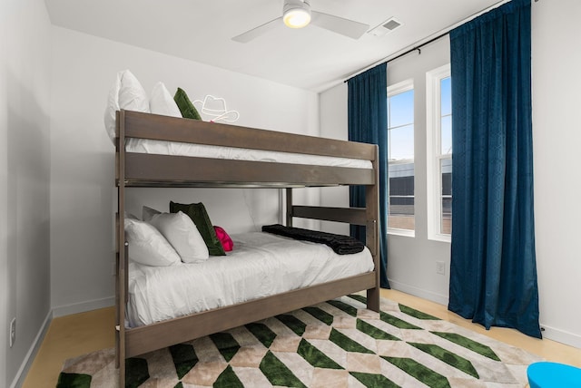 bedroom with ceiling fan, visible vents, and baseboards