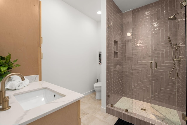 full bath featuring toilet, a shower stall, baseboards, and vanity