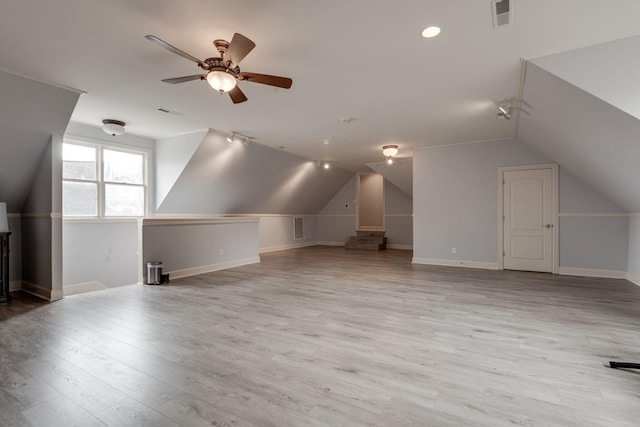 bonus room with lofted ceiling, light wood-style floors, and visible vents