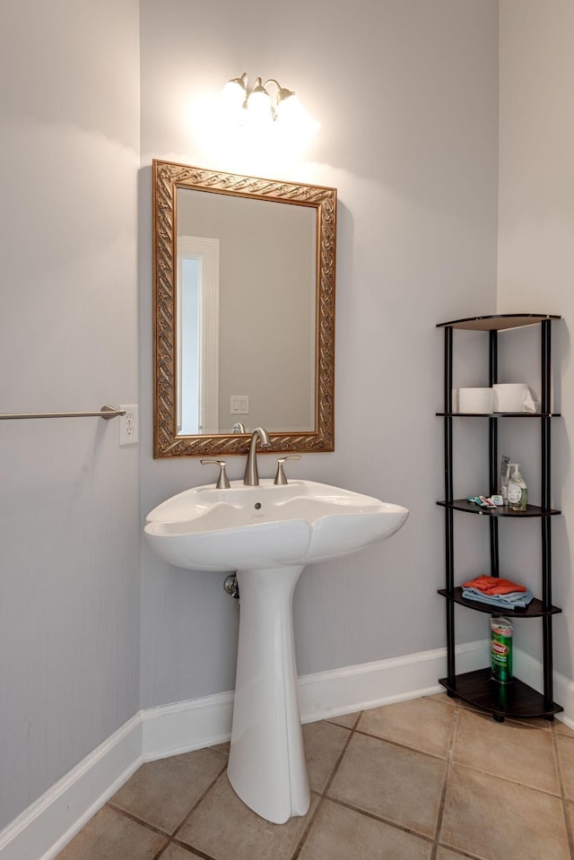 bathroom with a sink, tile patterned flooring, and baseboards