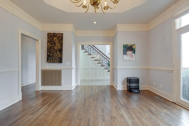 interior space featuring visible vents, stairway, ornamental molding, wood finished floors, and a chandelier