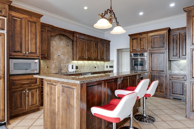 kitchen with stainless steel microwave, light tile patterned flooring, and crown molding