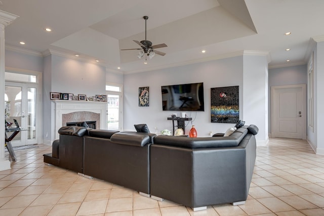 living room with light tile patterned floors, recessed lighting, a glass covered fireplace, and crown molding