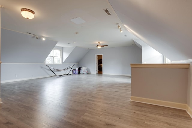 bonus room with light wood finished floors, lofted ceiling, visible vents, ceiling fan, and baseboards