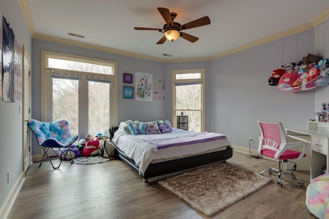 bedroom with visible vents, crown molding, and wood finished floors