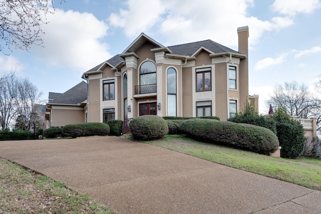 view of front facade featuring a chimney and stucco siding