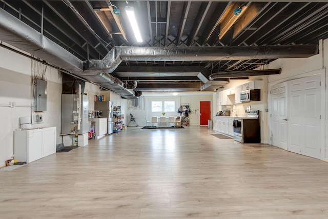 garage with heating unit, electric panel, and freestanding refrigerator