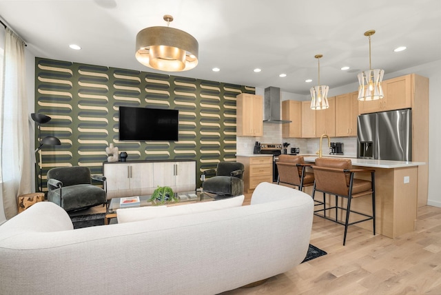 living room featuring wallpapered walls, light wood-style flooring, baseboards, and recessed lighting