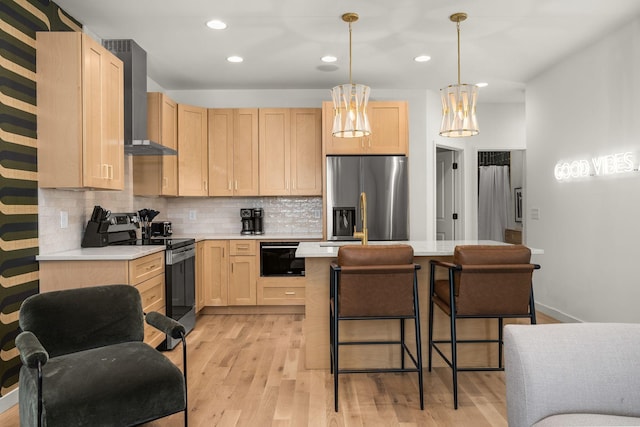 kitchen with range with electric stovetop, light countertops, wall chimney range hood, stainless steel fridge with ice dispenser, and light brown cabinetry