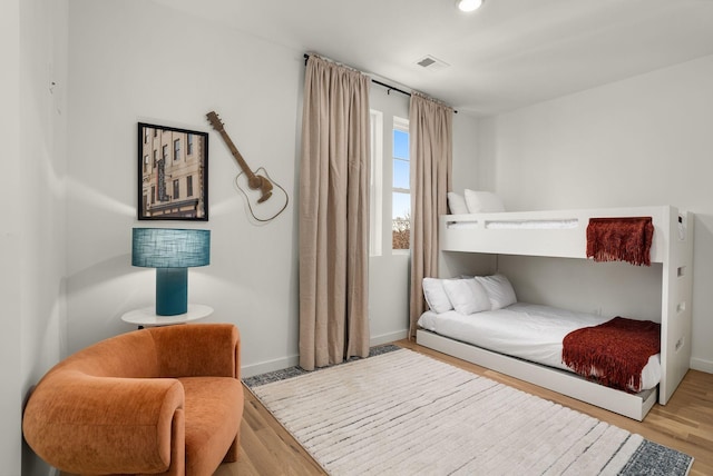 bedroom with baseboards, wood finished floors, and recessed lighting