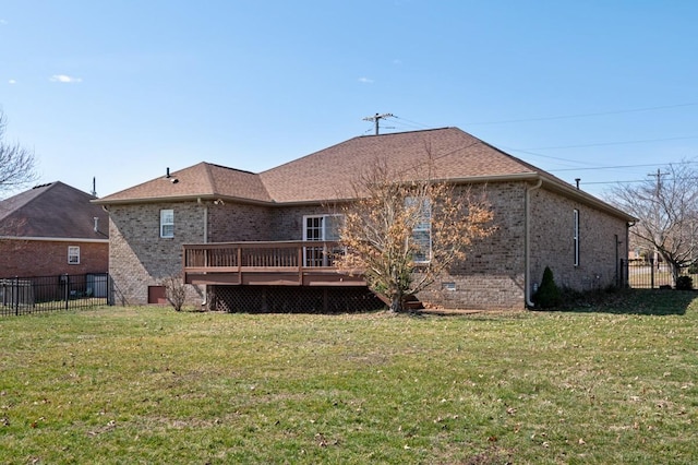 back of house with brick siding, a lawn, a wooden deck, and fence