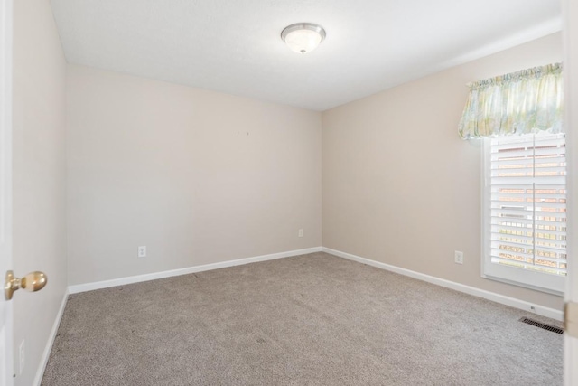 carpeted empty room with baseboards and visible vents