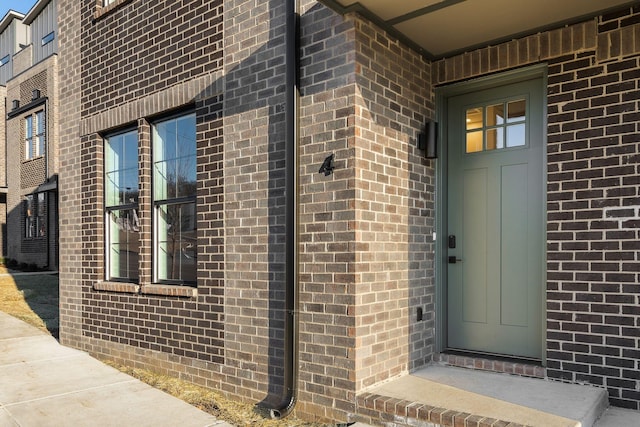 property entrance featuring brick siding