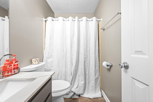 bathroom featuring toilet, a shower with curtain, wood finished floors, a textured ceiling, and vanity