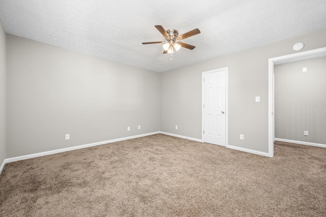 spare room featuring a textured ceiling, carpet flooring, a ceiling fan, and baseboards