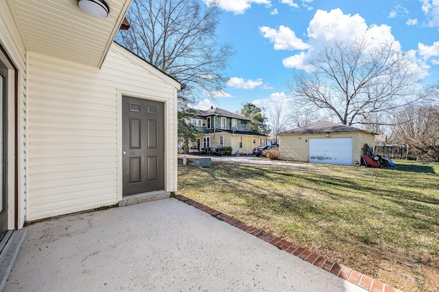 view of yard with an outbuilding, a patio area, and a garage