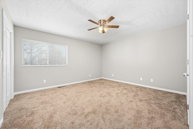 unfurnished room with carpet, ceiling fan, a textured ceiling, and baseboards