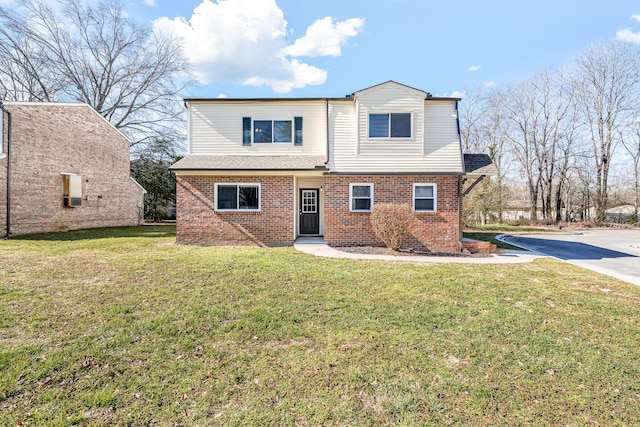 traditional-style house with brick siding and a front lawn