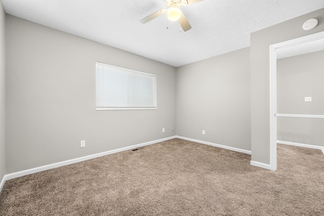 empty room with a ceiling fan, a textured ceiling, baseboards, and carpet flooring