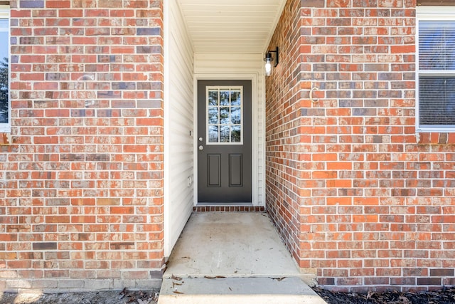 entrance to property featuring brick siding