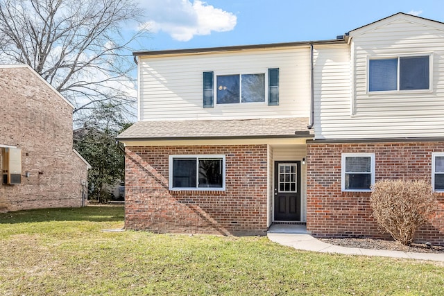 view of front facade featuring brick siding, a front yard, cooling unit, and a shingled roof