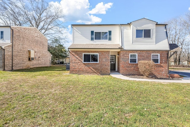 view of front of house with brick siding, a shingled roof, and a front yard