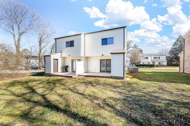 rear view of house featuring a lawn and a patio