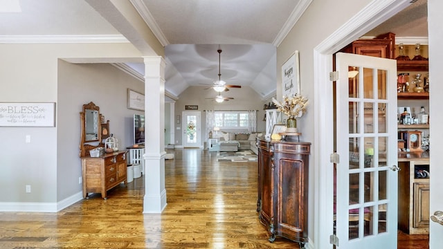 foyer featuring ornamental molding, ceiling fan, ornate columns, and wood finished floors