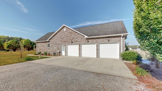 view of front of property with brick siding, a shingled roof, concrete driveway, a front yard, and a garage