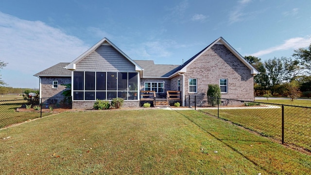 rear view of property with a sunroom, a fenced backyard, a yard, and brick siding