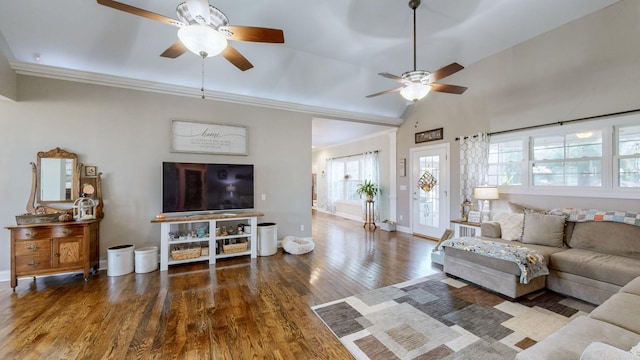 living room featuring a ceiling fan, vaulted ceiling, baseboards, and wood finished floors