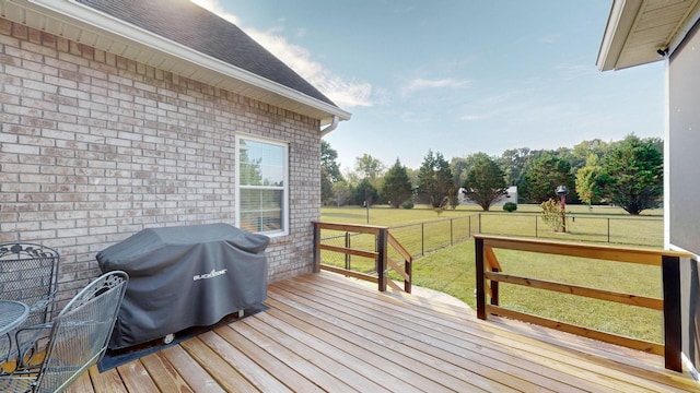 deck with a grill, a yard, and fence