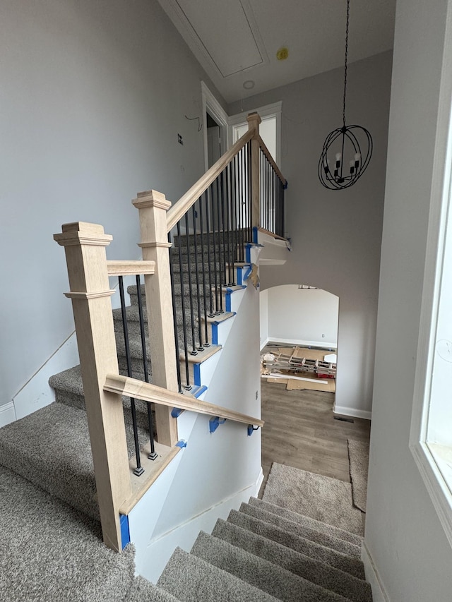 stairs featuring wood finished floors, attic access, and baseboards