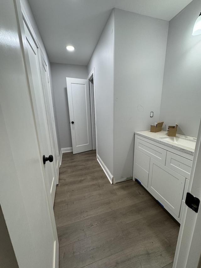 hallway featuring dark wood-style floors and baseboards