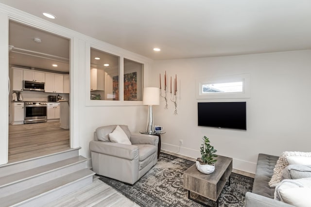 living room with recessed lighting, light wood-style flooring, and baseboards