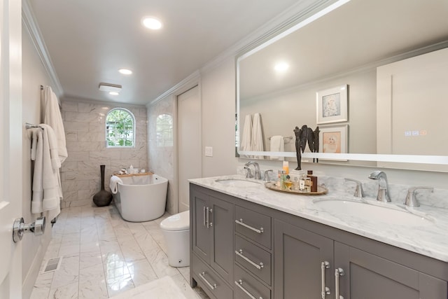 bathroom featuring marble finish floor, a freestanding tub, a sink, and crown molding