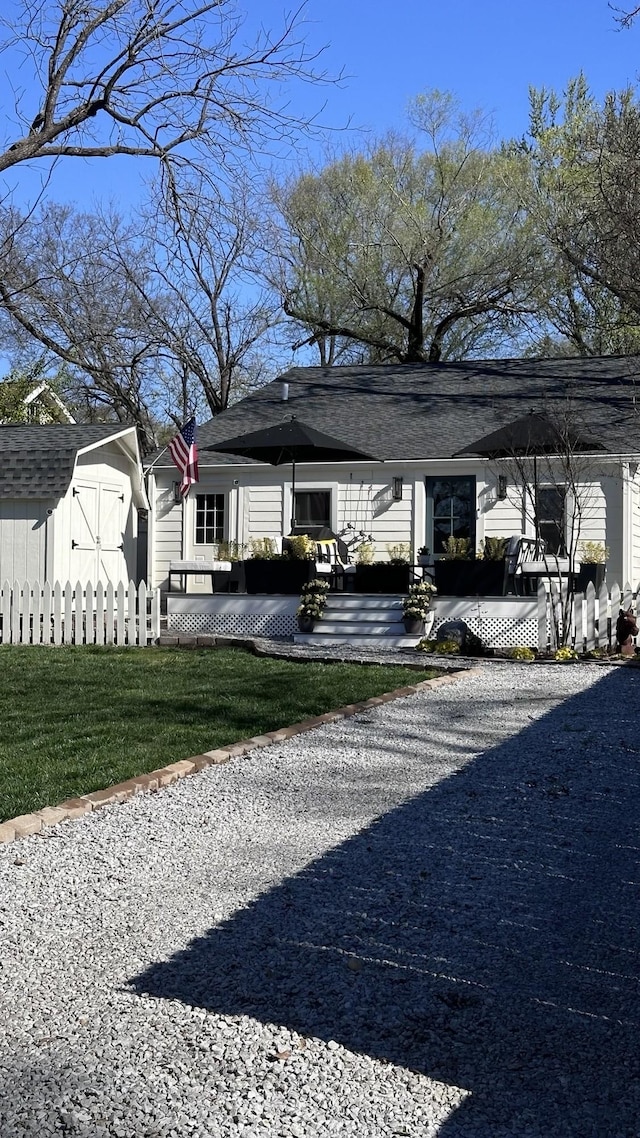 view of front facade with a storage unit, a front yard, a patio area, an outdoor structure, and driveway