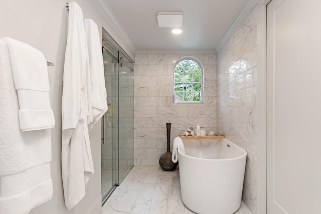 bathroom featuring marble finish floor, a shower stall, ornamental molding, and a soaking tub