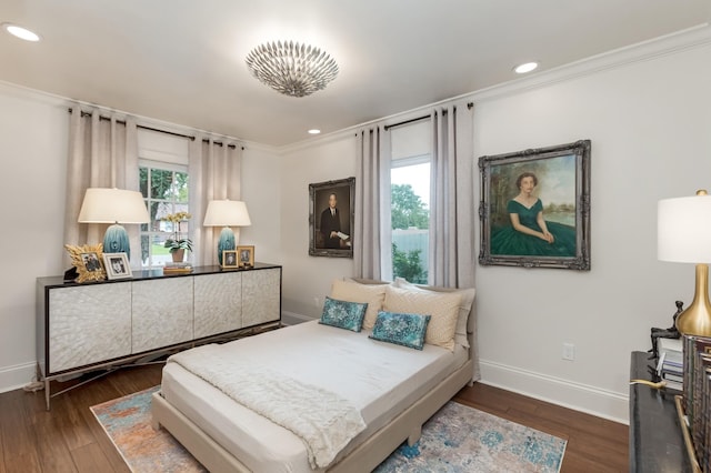 bedroom with ornamental molding, multiple windows, wood finished floors, and baseboards