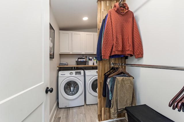 clothes washing area with cabinet space, washing machine and dryer, light wood-style flooring, and recessed lighting