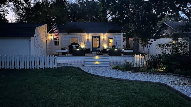 view of front of home with fence and a front lawn